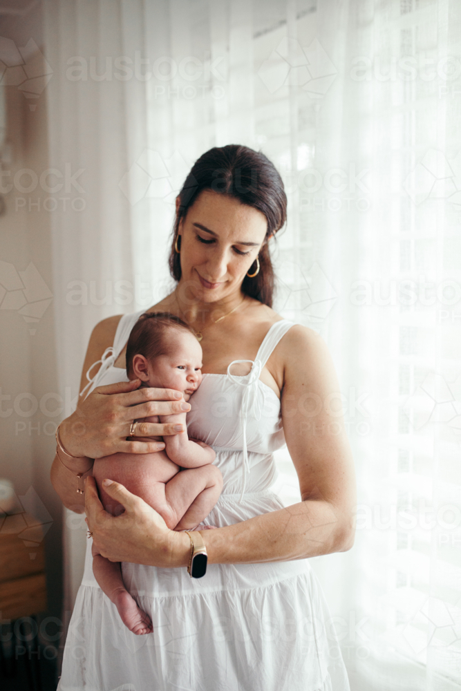Newborn baby girl resting on mother's chest - Australian Stock Image