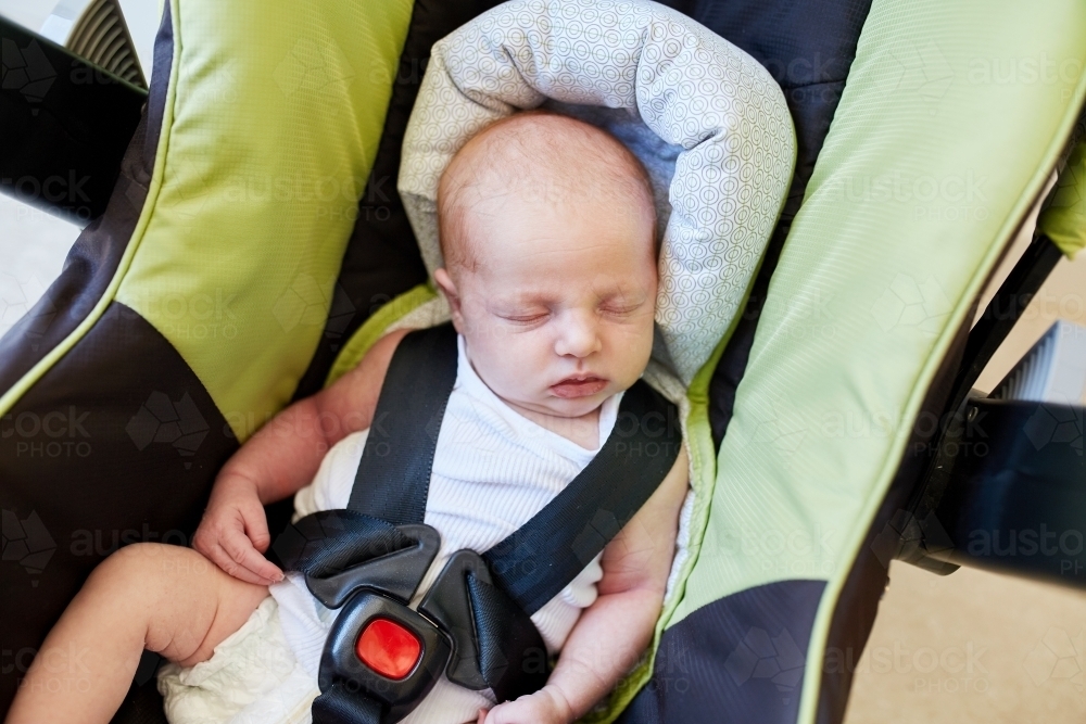 Newborn baby sleeping in baby capsule - Australian Stock Image