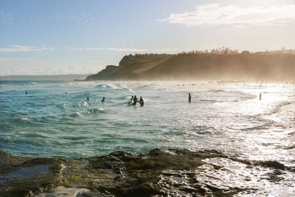 Newcastle beach late afternoon with sea mist in front of the cliff - Australian Stock Image