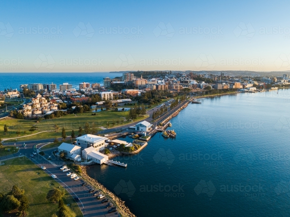 Newcastle Harbour at sunset with last light on seaside buildings on the foreshore - Australian Stock Image