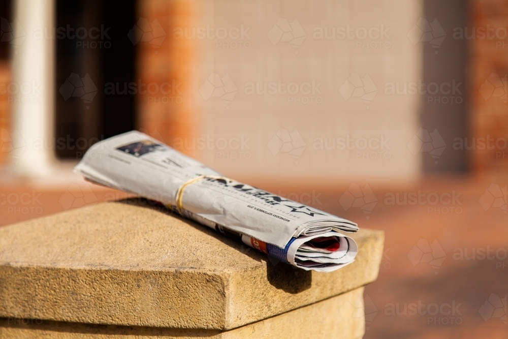 Newspaper rolled up and placed on mailbox in front of home - Australian Stock Image
