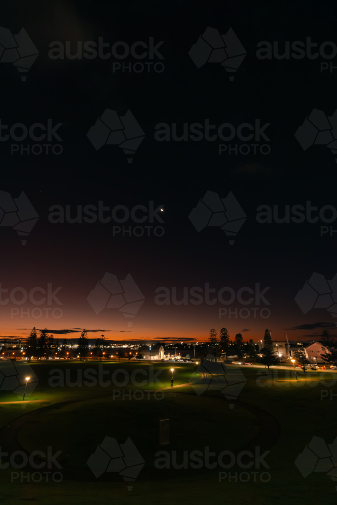 Night sky over Newcastle city with vibrant moon - Australian Stock Image