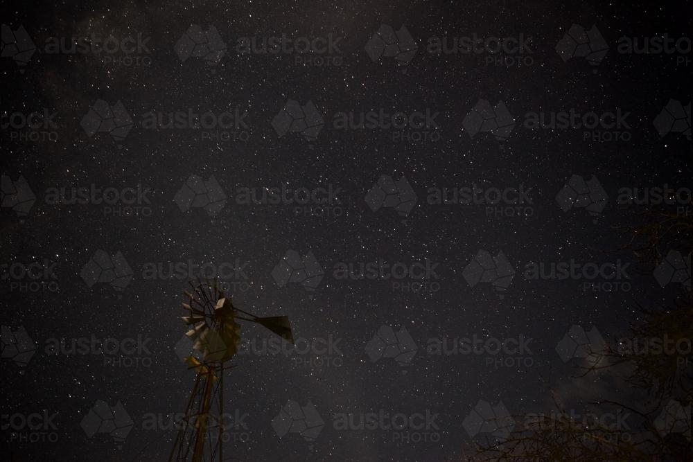 Night sky with stars and a windmill in the foreground - Australian Stock Image