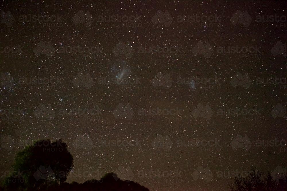 Night sky with stars and the large and small magellanic cloud galaxies - Australian Stock Image