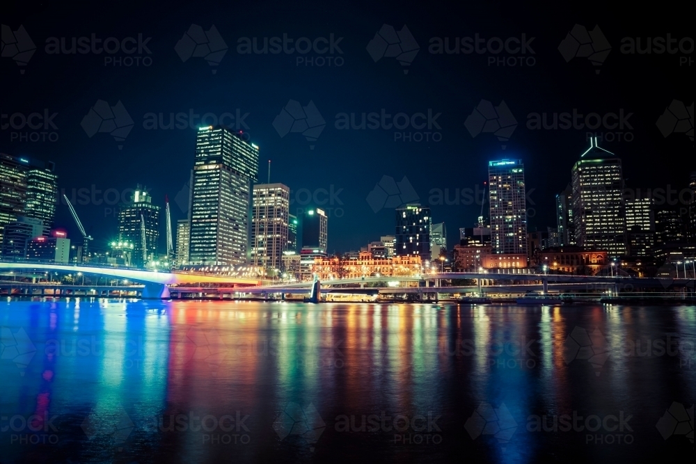 Night view of Brisbane high rise buildings and coloured lights in water - Australian Stock Image