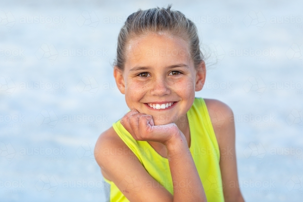 nine-year-old girl head and shoulders with hand on chin - Australian Stock Image