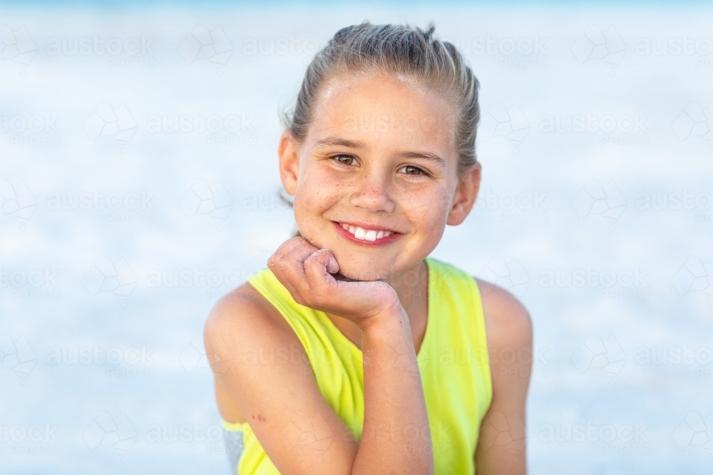 nine-year-old girl head and shoulders with hand on chin - Australian Stock Image