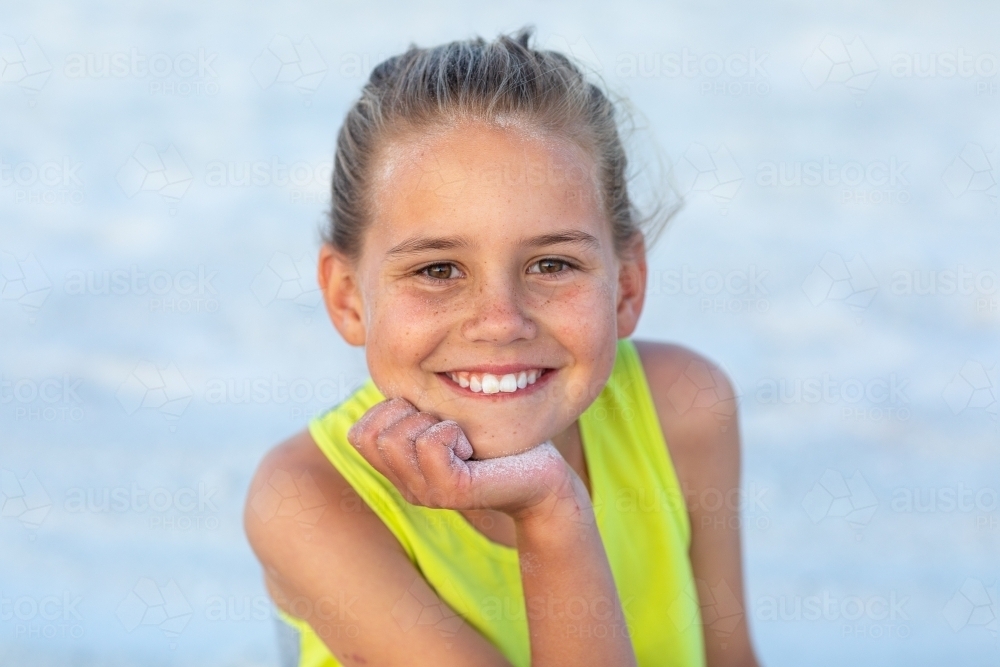 nine-year-old girl head and shoulders with hand on chin - Australian Stock Image