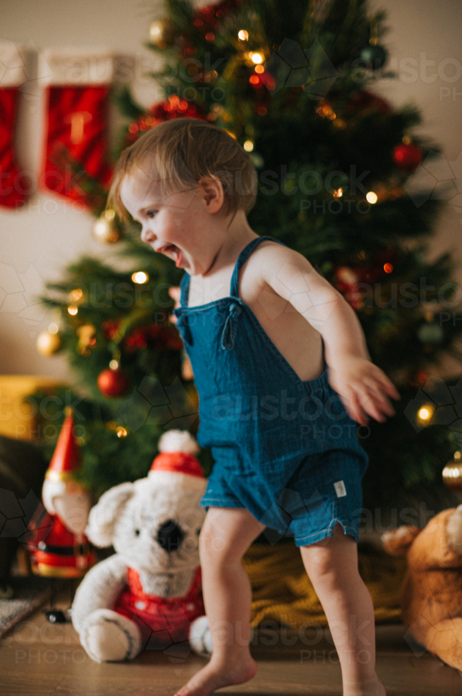 no focus image of playful blonde girl dancing happily near the Christmas tree - Australian Stock Image