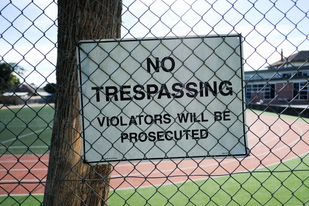 No trespassing sign attached to a large fence - Australian Stock Image