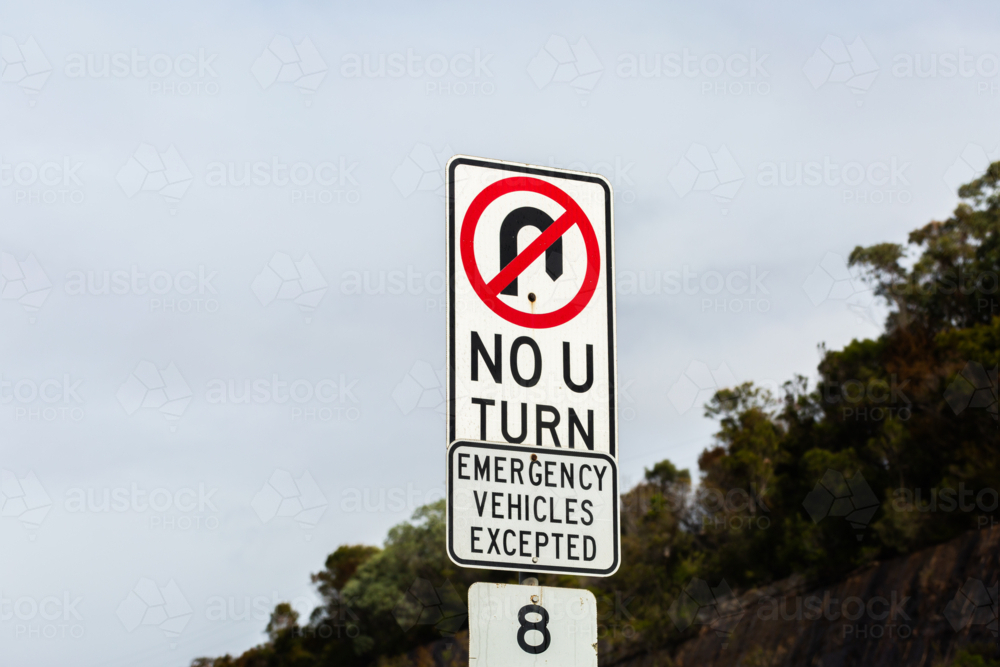 no u turn sign emergency vehicles excepted beside highway - Australian Stock Image