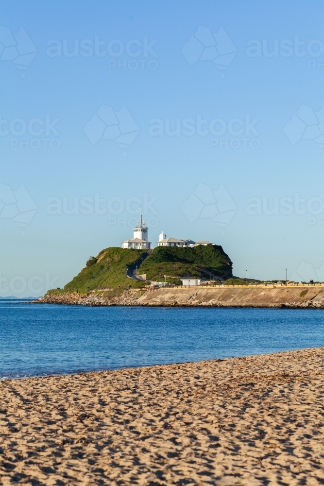 Nobbys Head Lighthouse across water of river estuary - Australian Stock Image
