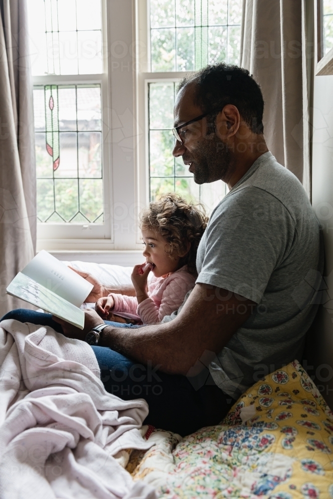 Daddy and little girl story time - Australian Stock Image