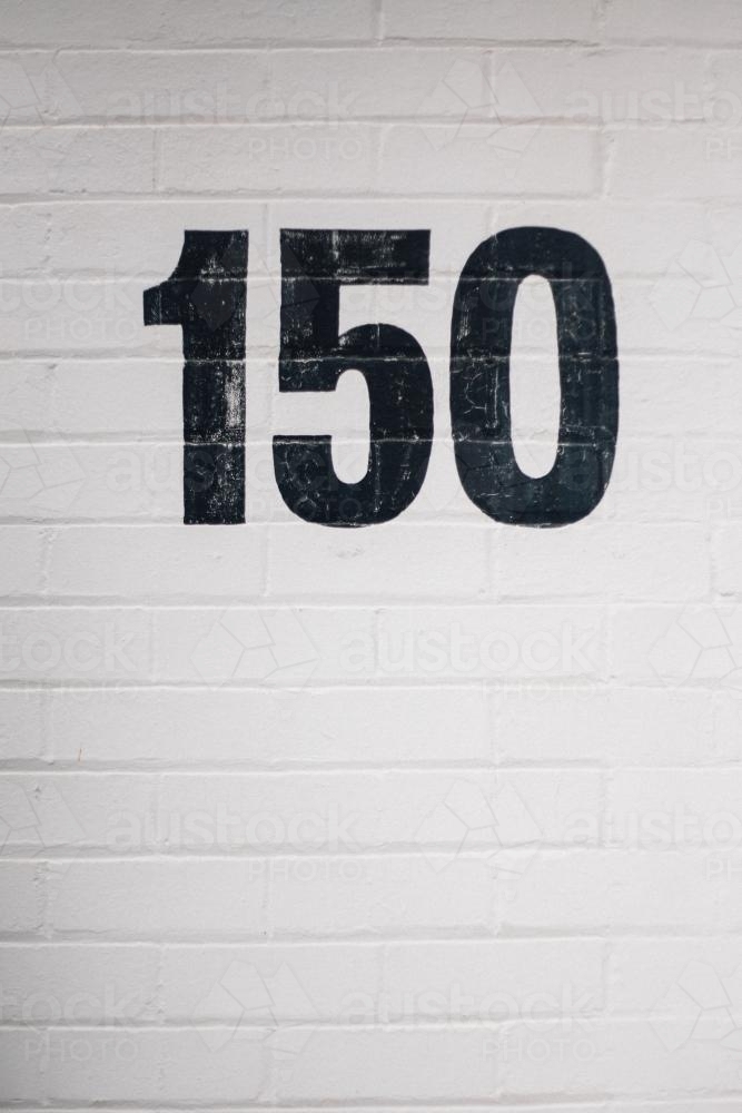 Number 150 Painted on Brick Wall - Australian Stock Image