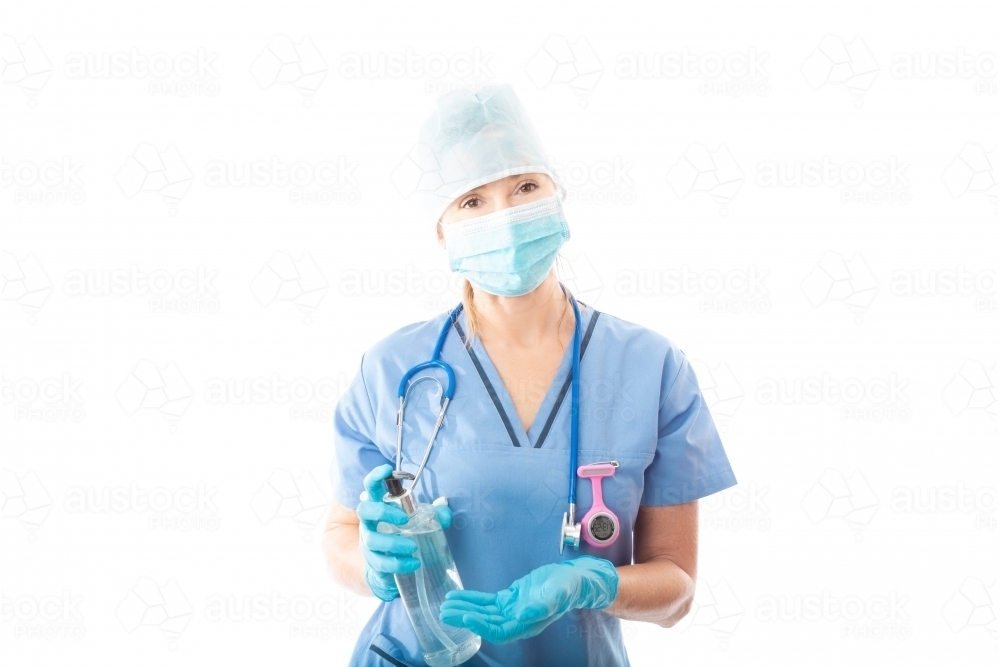 Nurse or doctor holding showing bottle of alcohol hand sanitizer to stop infection of virus pathogen - Australian Stock Image