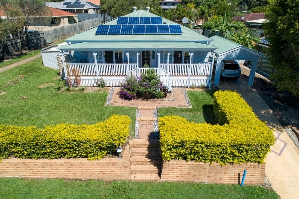 Oblique aerial view of Queenslander style house with solar panels. - Australian Stock Image