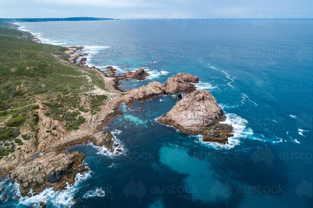 Oblique aerial view of rugged coastline, ocean, and islands.. - Australian Stock Image