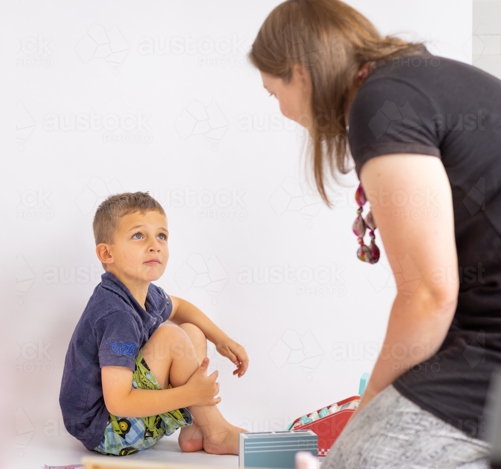 occupational therapist communicating with young child - Australian Stock Image