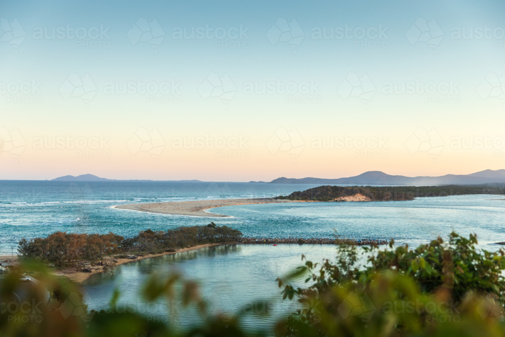 Ocean view of coastal inlet and sandbar at sunset - Australian Stock Image