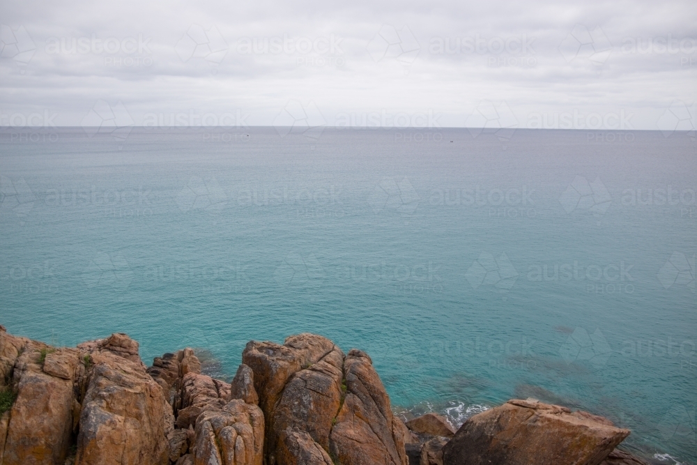 Image of Ocean view with rocks in the foreground on overcast day ...