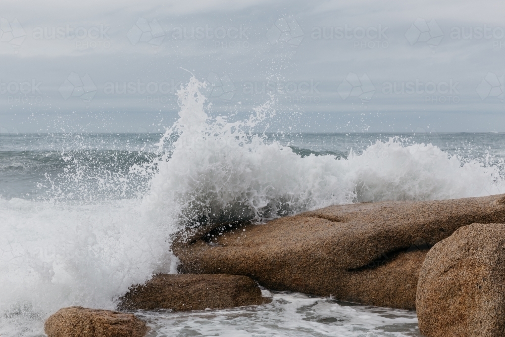 Ocean waves breaking over rocks - Australian Stock Image
