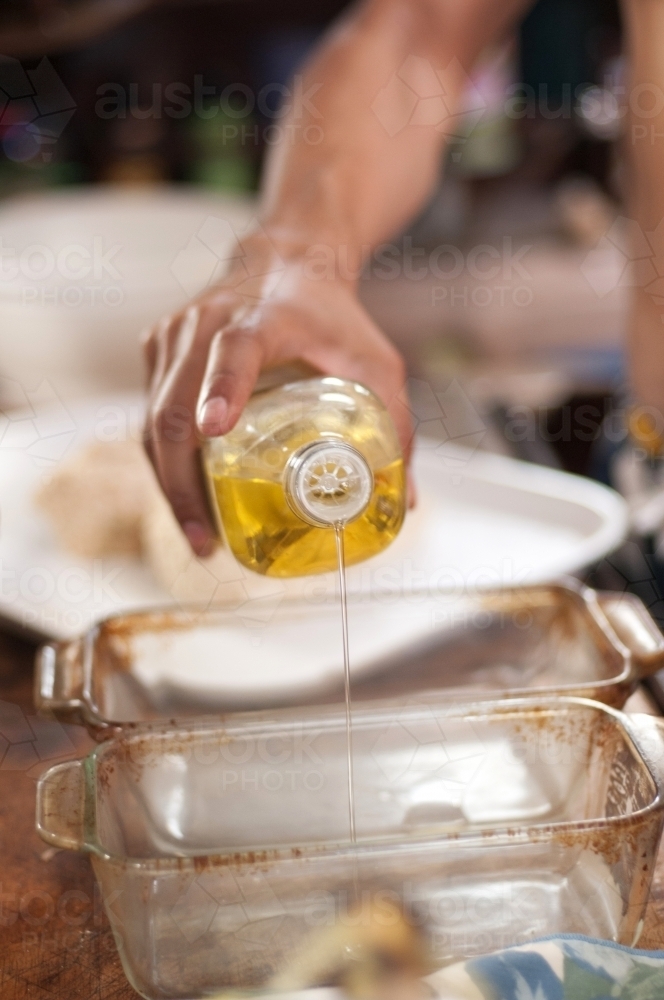 Oiling pans for baking bread - Australian Stock Image