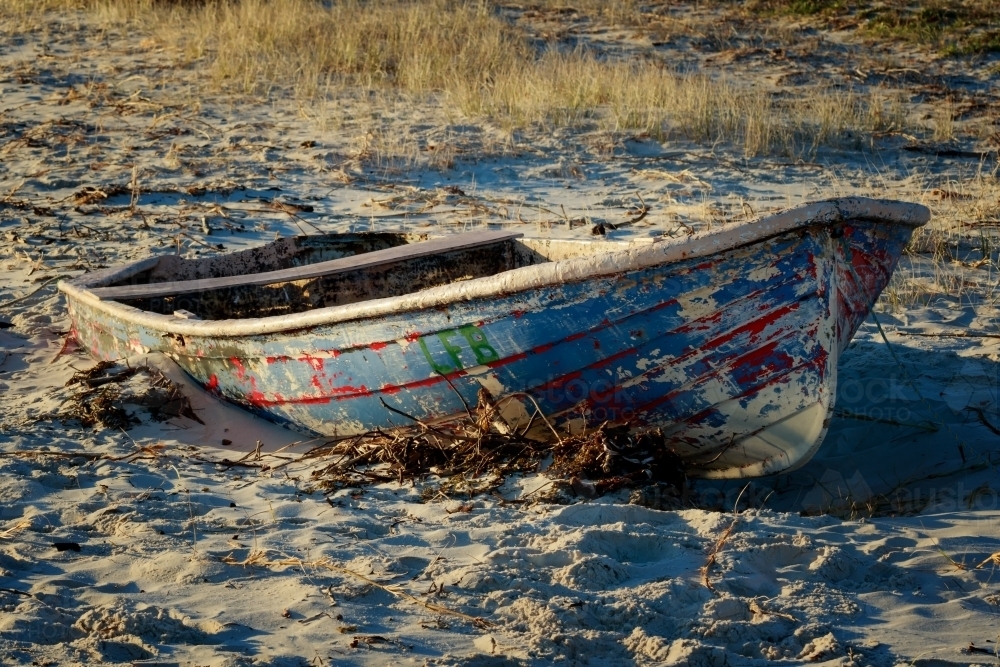 Old, abandoned dinghy on beach - Australian Stock Image