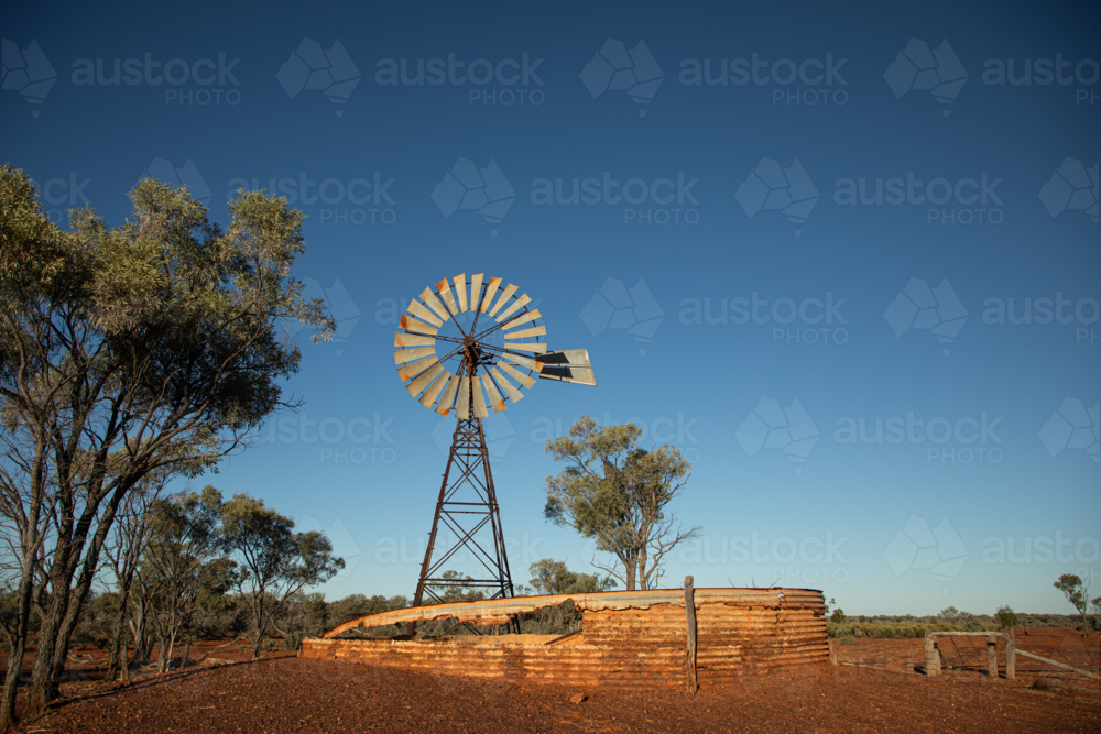 Old abandoned windmill and turkey nest with gidgea trees - Australian Stock Image
