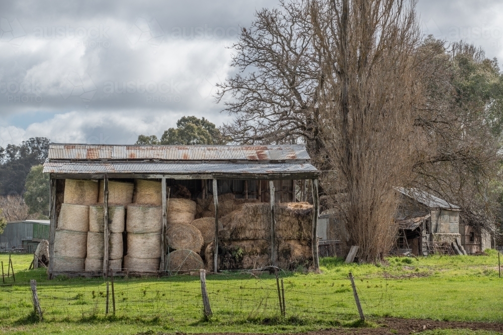 Old barn and hay rolls in country shed on farm - Australian Stock Image
