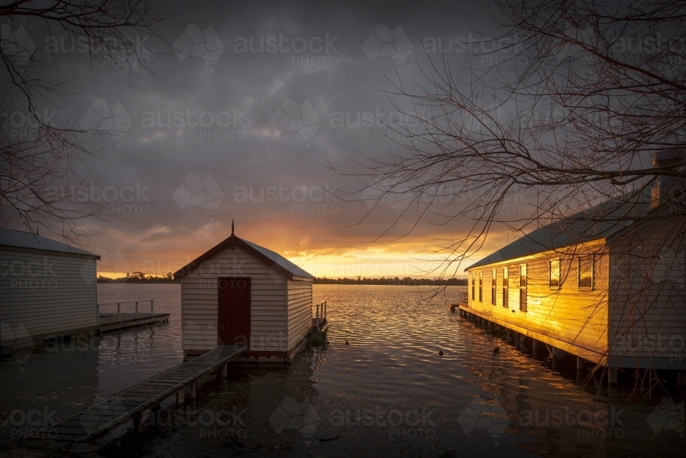 Old boat sheds on lake at sunset - Australian Stock Image