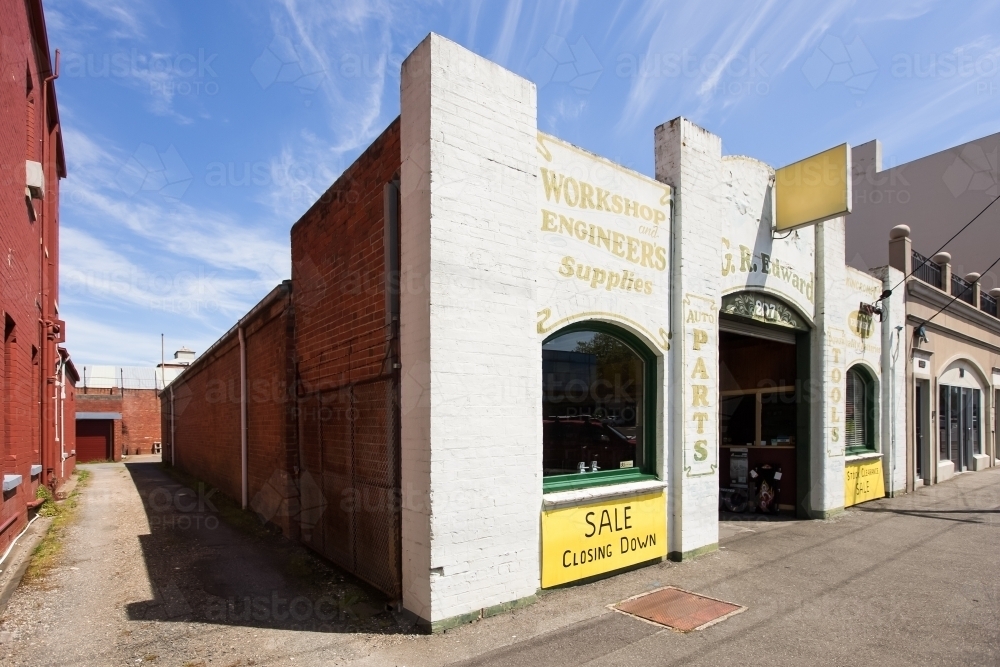 Old brick building with closing down sign - Australian Stock Image