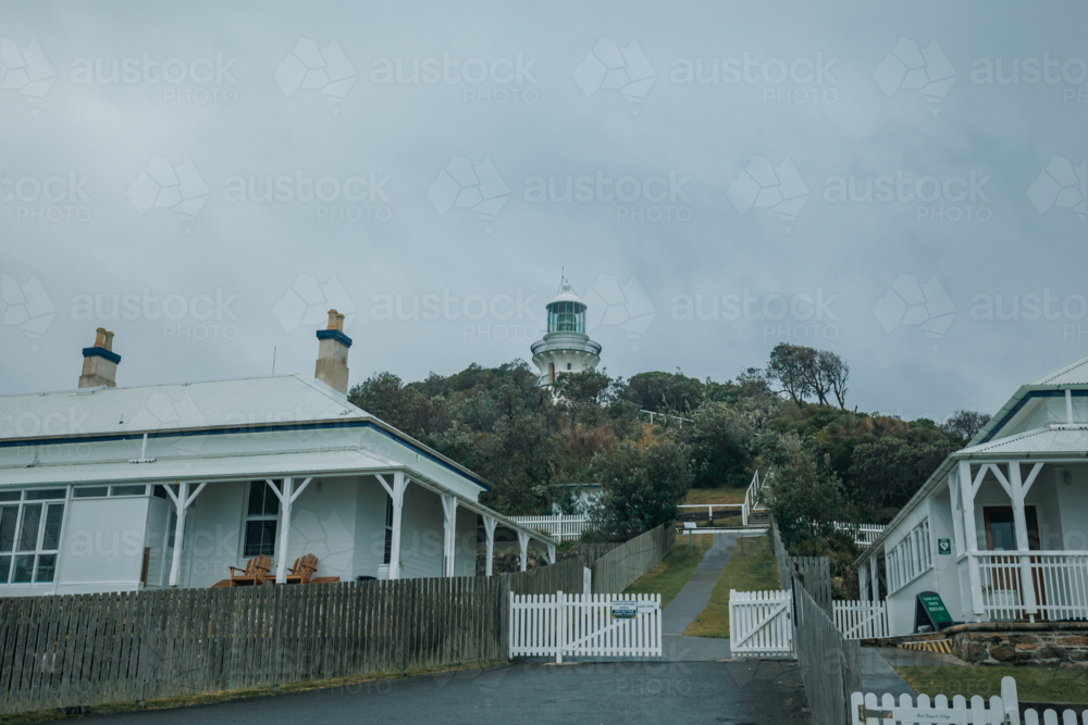 Old buildings at Sugarloaf Point with lighthouse in background - Australian Stock Image