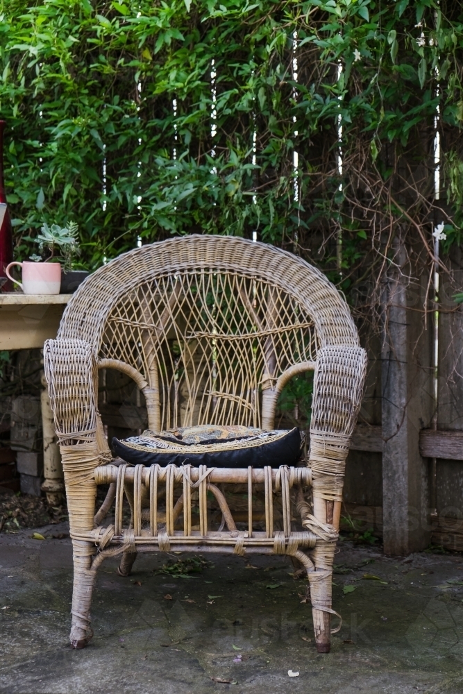 Old cane chair in the garden. - Australian Stock Image