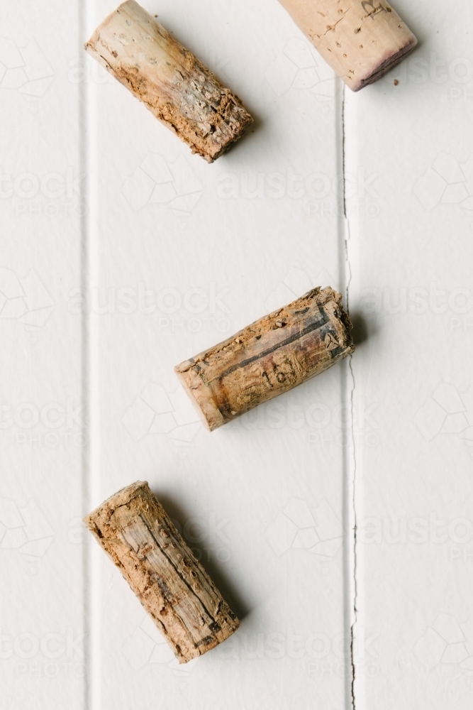 old corks on a white wooden background - Australian Stock Image