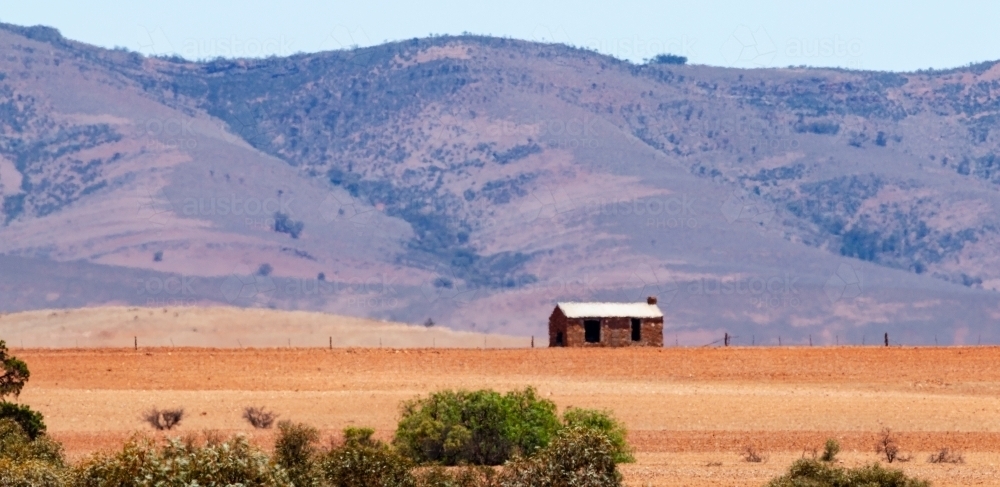 old cottage in front of hills - Australian Stock Image