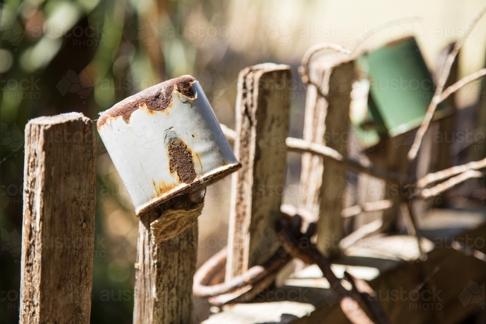 Old enamel tin cups on wooden fence pickets - Australian Stock Image