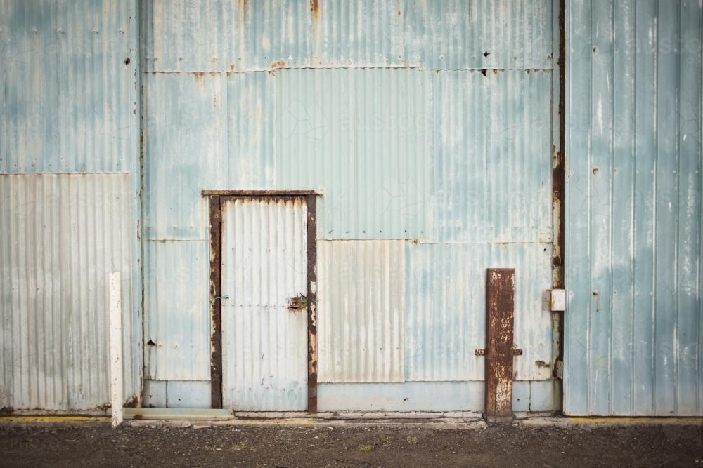 Old faded blue corrugated iron shed and door - Australian Stock Image