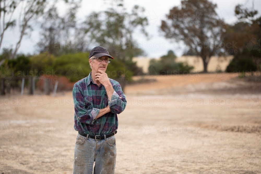 old farmer in dirty clothes outdoors on farm - Australian Stock Image