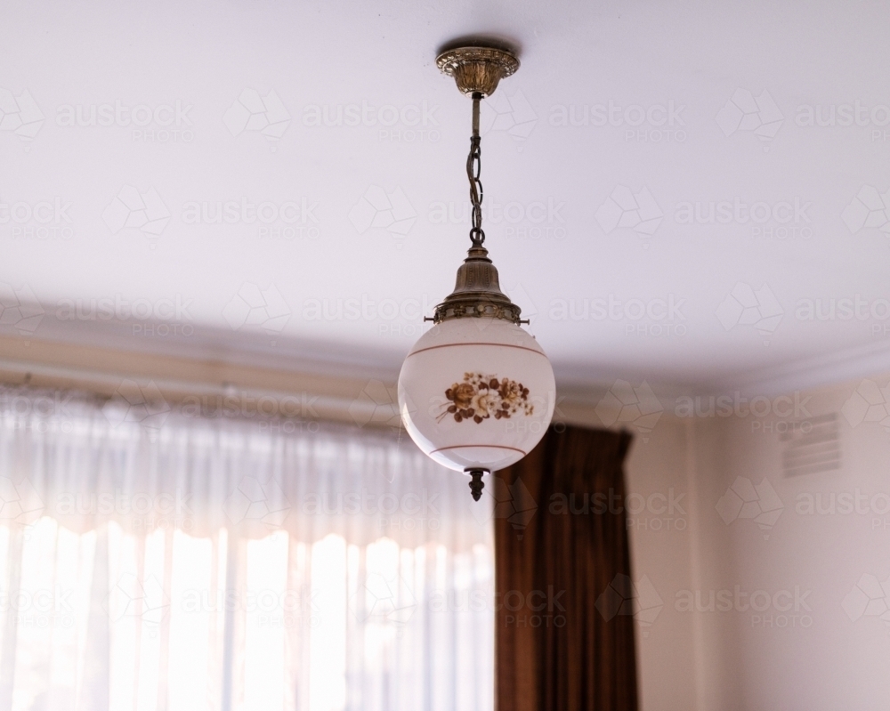 Old fashioned ceiling light hanging in a bedroom - Australian Stock Image