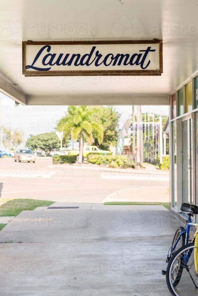 Old fashioned laundromat sign and empty footpath - Australian Stock Image