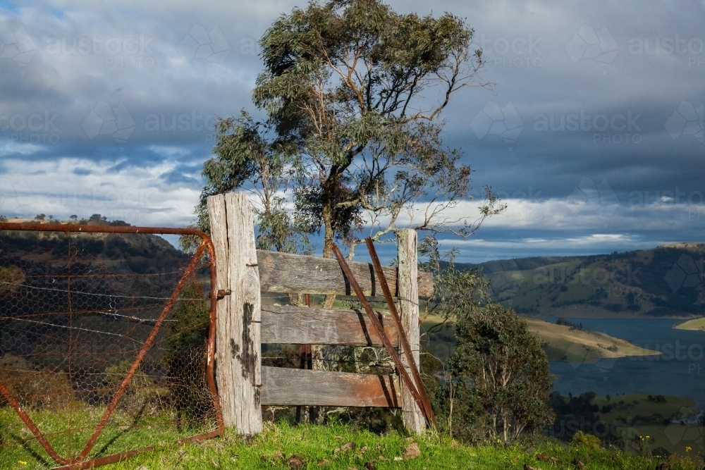 Old fence and gate in the hills lit by morning light - Australian Stock Image