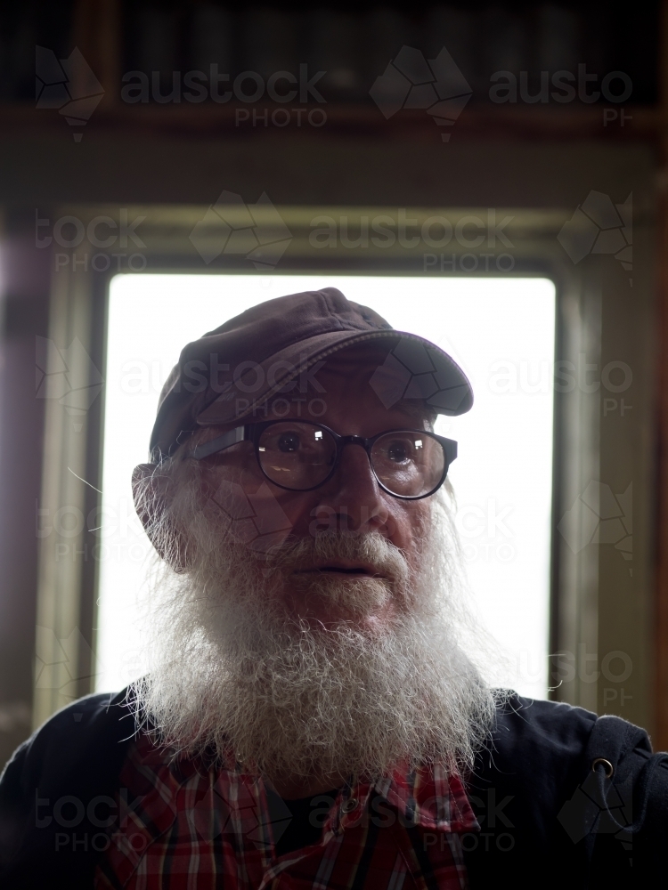 Old Man in Window Light - Australian Stock Image