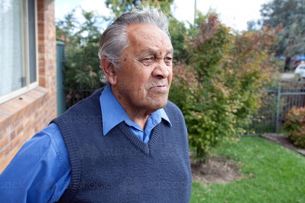 Old man standing outside his house - Australian Stock Image