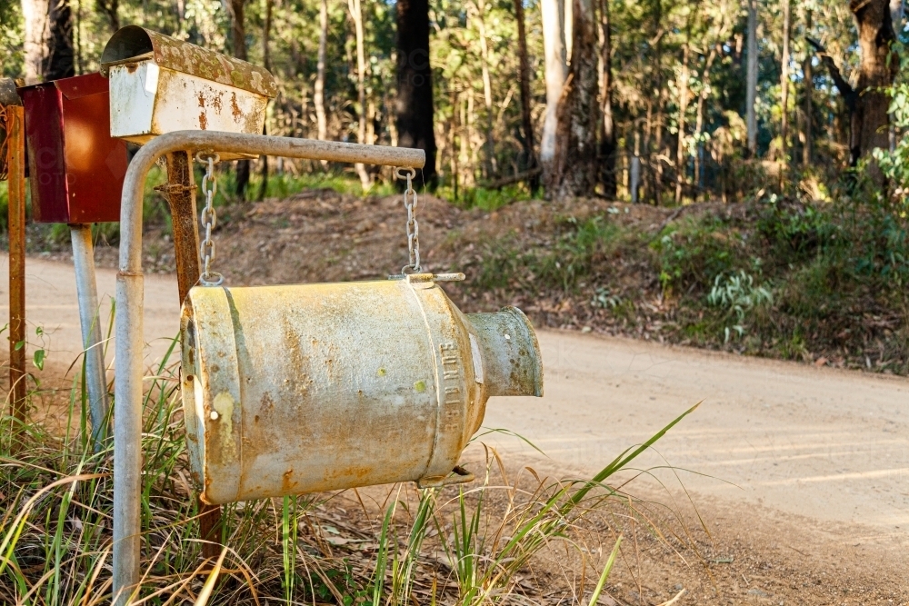 Old milk can as country mailbox at property entrance - Australian Stock Image