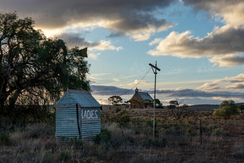old outside toilet with church in background - Australian Stock Image