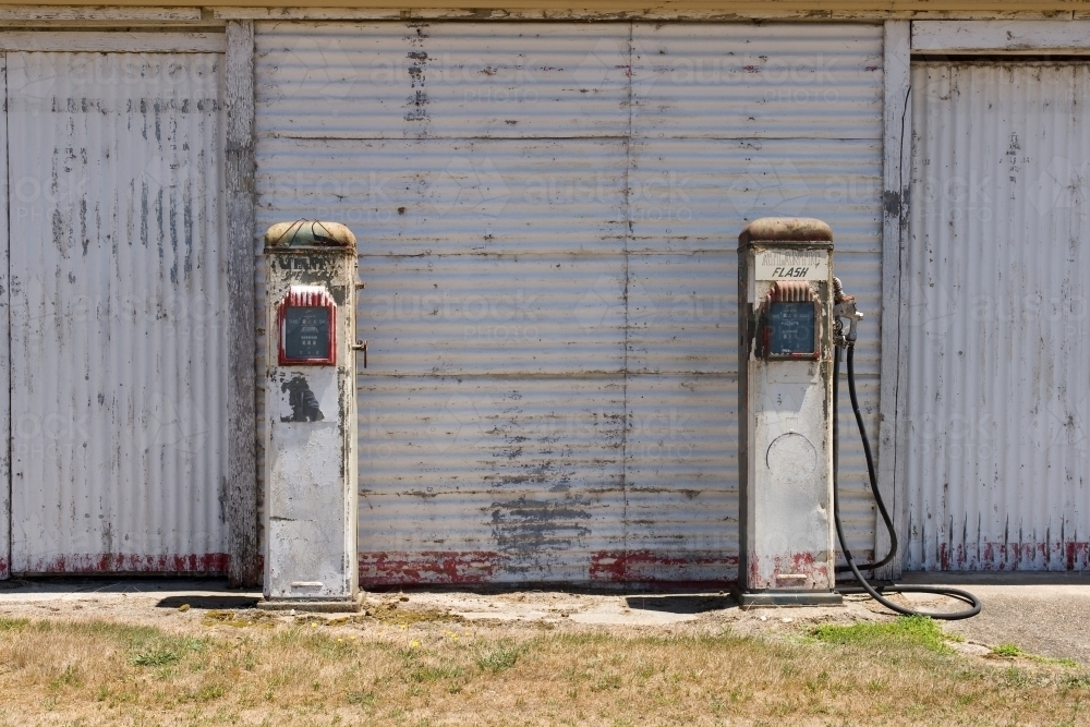 old petrol bowsers in front of a corrugated iron shed - Australian Stock Image