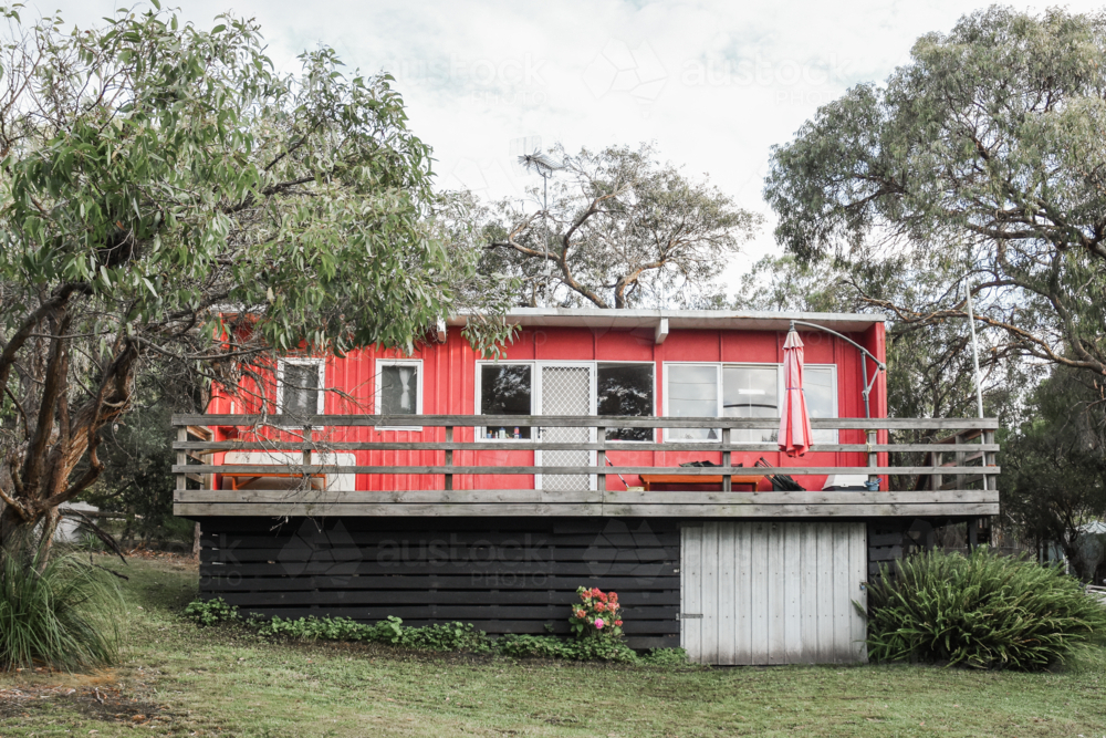 Old red beach shack with gum trees - Australian Stock Image