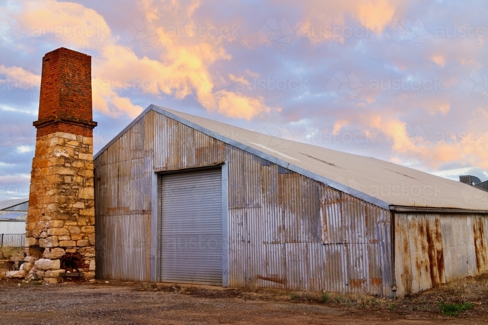 Old shed and stone chimney at sunset - Australian Stock Image