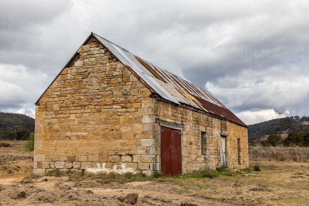 Old stone brick building in a field - Australian Stock Image