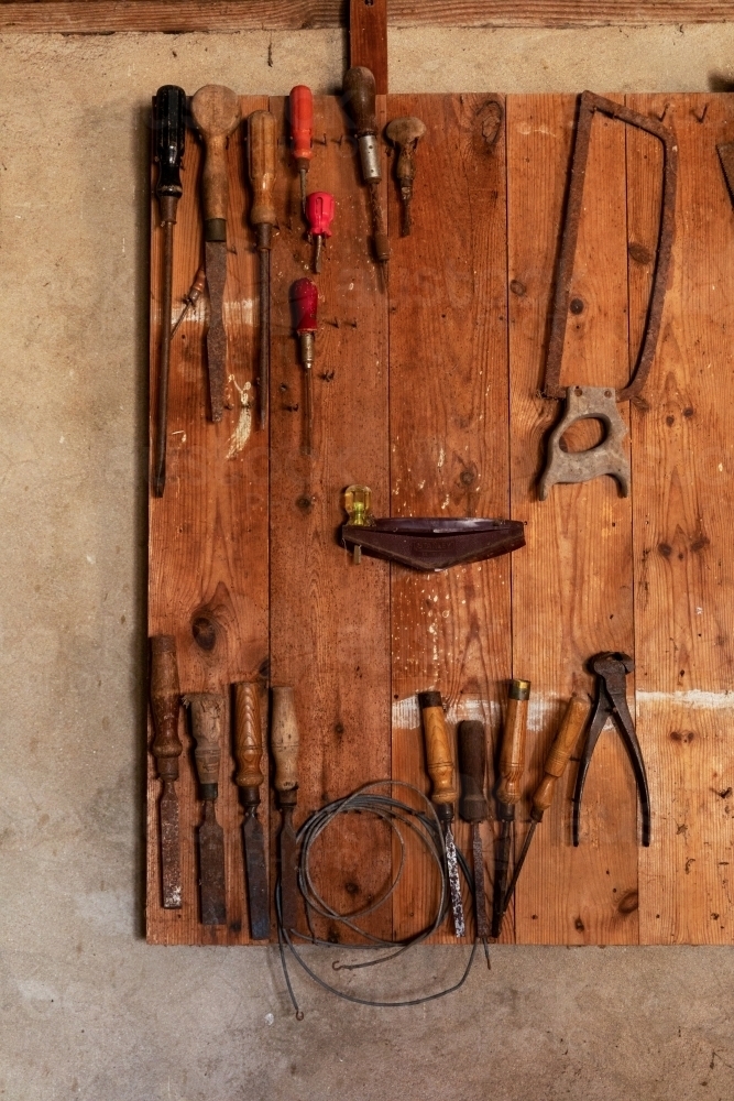 old tools hanging on wooden board - Australian Stock Image